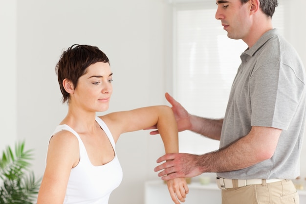 Foto quiropráctico trabajando en el brazo de una mujer