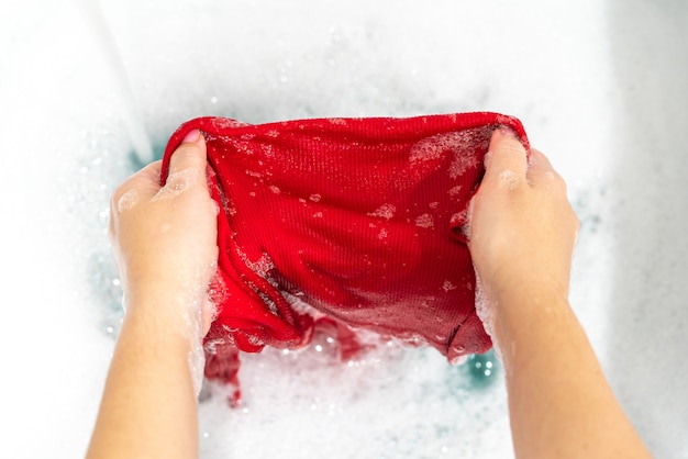 Quitar la mancha con el lavado de manos de la ropa roja