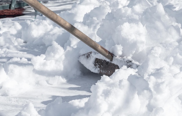 Quitar la nieve con una gran pala de madera