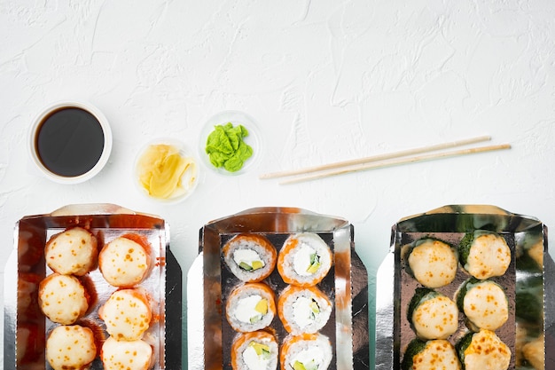 Quitar rollos de sushi en contenedores, rollos philadelphia y rollos de gambas al horno, en piedra blanca