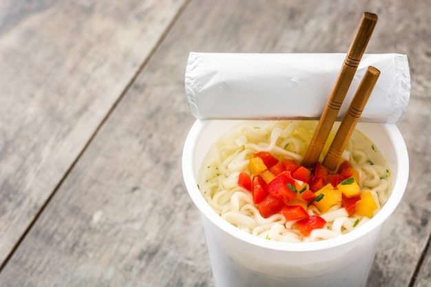 Quite los fideos con verduras en la mesa de madera, copie el espacio