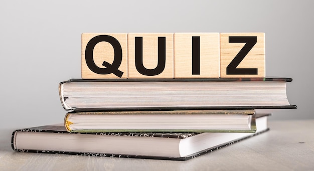Quiz-Wort auf Holzblöcken und Büchern für die Bildung Quiz-Test für Wissen