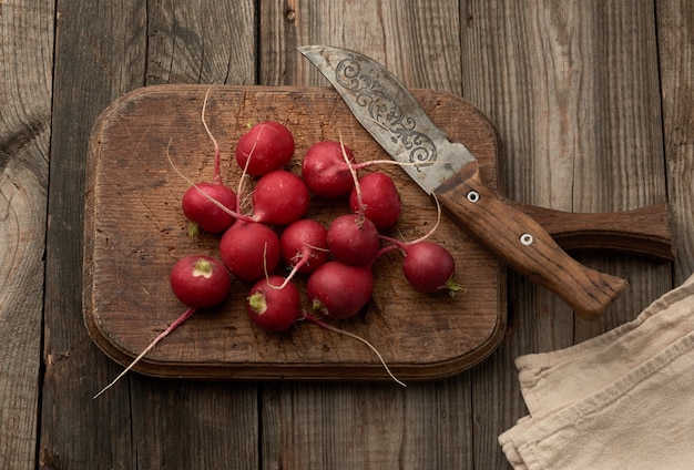 Rabanete vermelho redondo em uma mesa de cozinha vintage, cinza mesa de madeira
