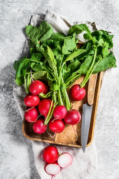 Rábanos rojos frescos en un tazón de madera. Cultivar vegetales orgánicos. Vista superior