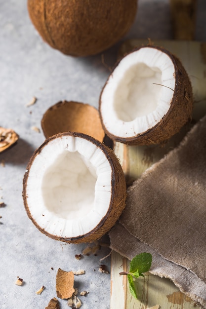 Rachado coco fresco, leite e fatia de noz em fundo de concreto, espaço para texto Ingredientes alimentares, estilo de vida saudável, paraíso