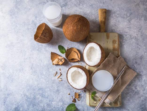 Rachado coco fresco, leite e fatia de noz em fundo de concreto, espaço para texto ingredientes alimentares, estilo de vida saudável, paraíso