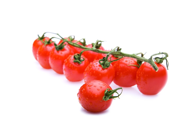 Racimo de tomates rojos con gotas de agua