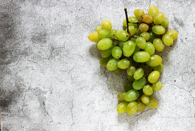 Racimo de uvas ámbar sobre un hormigón gris