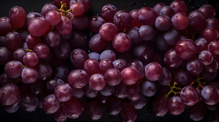 Un racimo de uvas está en una bandeja negra.