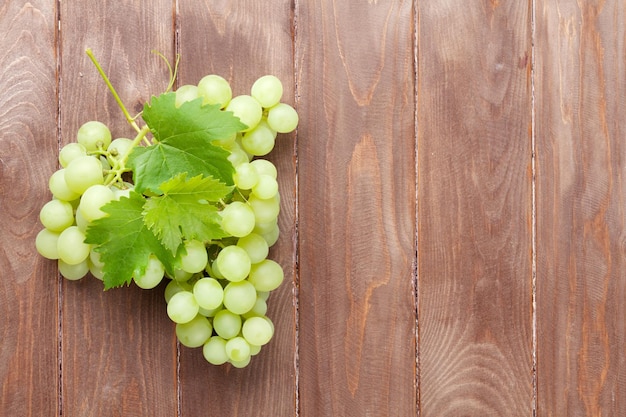 Racimo de uvas en mesa de madera