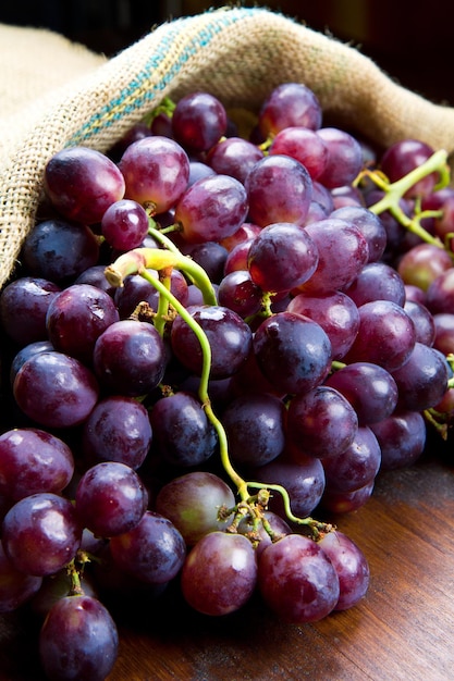 Foto racimo de uvas negras sobre fondo de madera