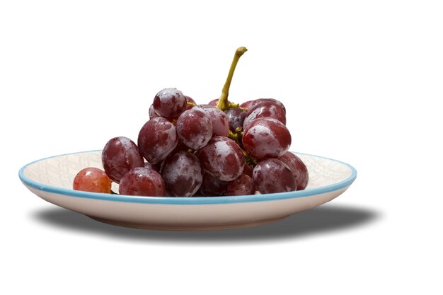 Racimo de uvas rojas en plato blanco