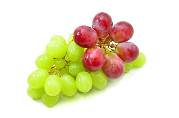 Un racimo de uvas rojas y verdes aislado sobre fondo blanco.