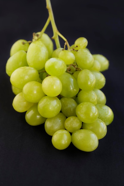 Racimo de uvas verdes aislado sobre fondo negro