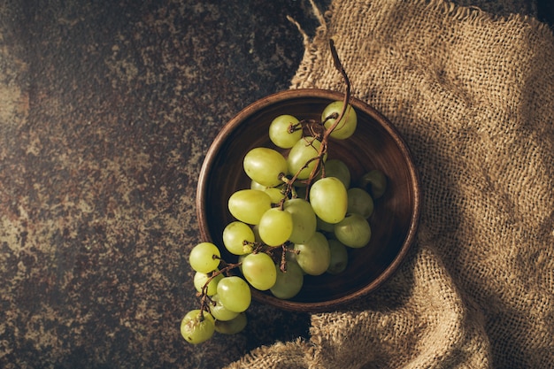 Racimo de uvas verdes sobre un fondo oscuro.