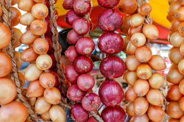 Racimos de cebolla en puesto de mercado al aire libre.