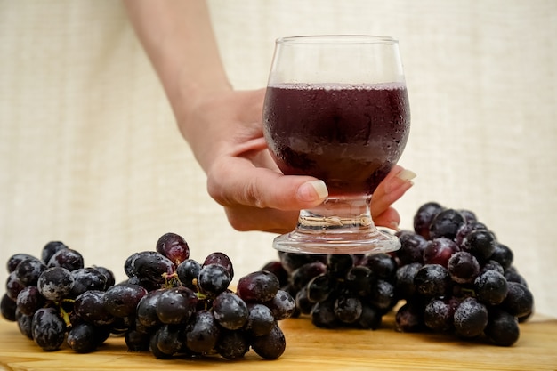 Racimos de uvas negras de agricultores orgánicos naturales sobre fondo de placa negra vista superior taza de cerca