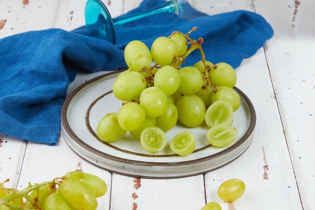 Racimos de uvas verdes maduras frescas en una mesa de madera