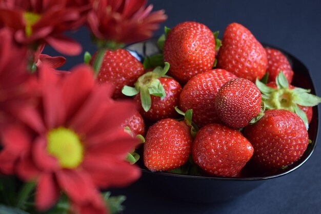 Una ración de fresas frescas sobre un fondo negro