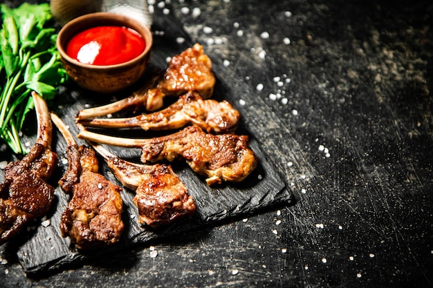 Rack de cordero con salsa de tomate y perejil sobre la mesa