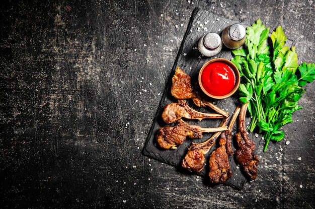 Rack de cordero con salsa de tomate y perejil sobre la mesa