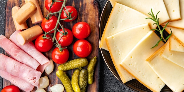 Raclette-Käse-Snack-Vorspeise-Essen auf dem Tisch, Kopienraum, Lebensmittelhintergrund, rustikale Draufsicht