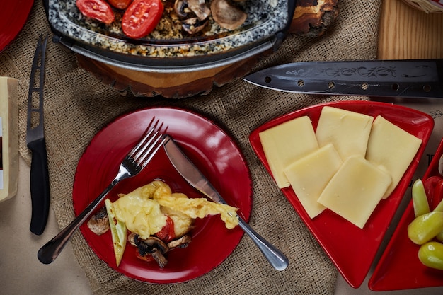 Raclettekäse geschmolzen mit Kartoffeln und Fleisch. Ansicht von oben.