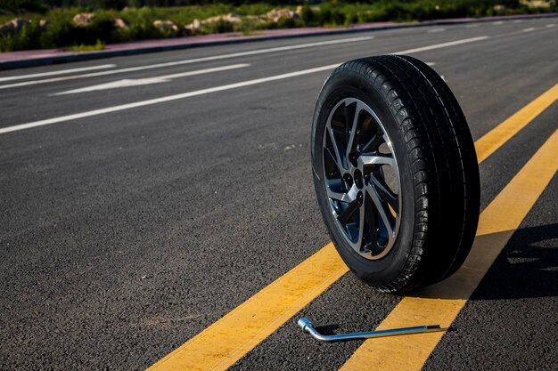 Foto rad auto autoreifen aluminiumfelgen oder stahlfelgen isoliert auf straßenhintergrund autoreifen mit einem tollen profil im autoreparaturbild über reifenauto schöner kopierraum für text