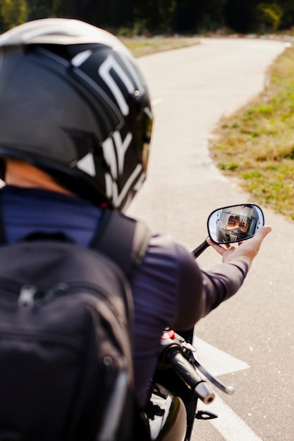 Radfahrer, der den Motorradrückspiegel repariert