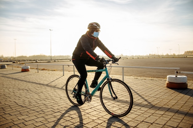 Radfahrer fährt während der Quarantäne ein Fahrrad in einer Maske