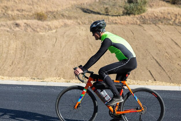 Radfahrer fahren Fahrrad auf der Straße gegen den klaren Himmel