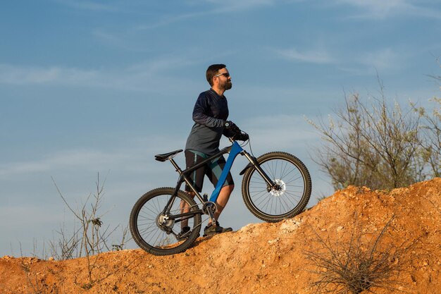 Radfahrer in Hose und Fleecejacke auf einem modernen Fahrrad mit Luftfedergabel fährt Offroad