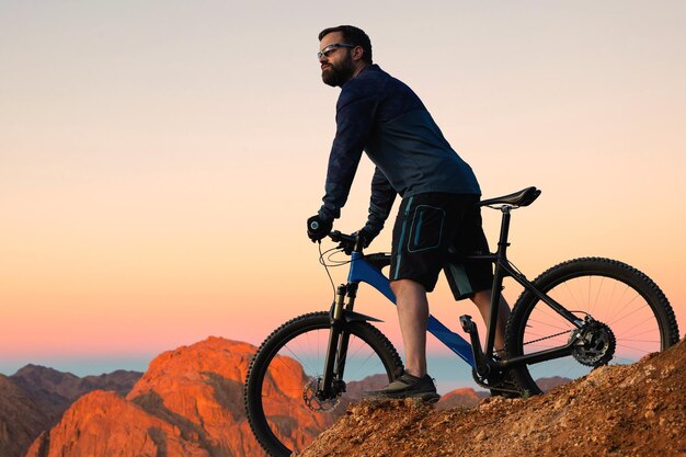 Radfahrer in Hose und Fleecejacke auf einem modernen Fahrrad mit Luftfedergabel fährt Offroad