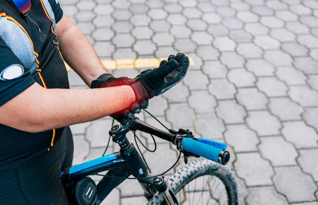 Radfahrer mit Handschmerzen im Freien Nahaufnahme eines Radfahrers mit Arthritis im Freien