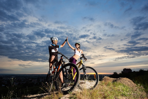 Radfahrer mit Mountainbikes bei Sonnenuntergang