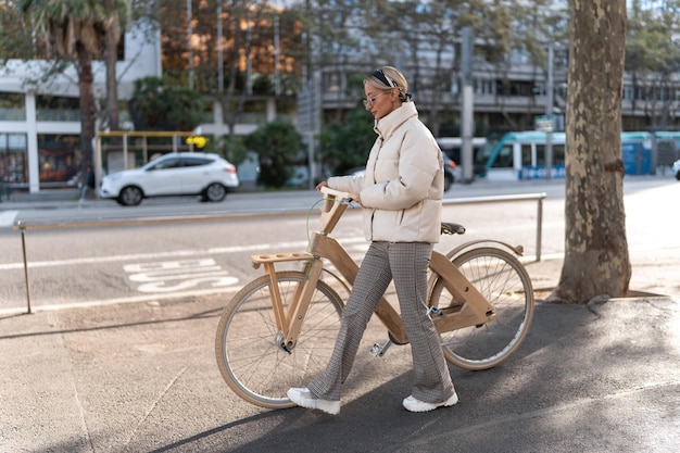 Radfahrerin, die in der Nähe der Straße spazieren geht