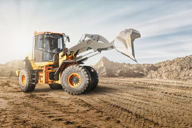 Radfrontlader oder Bulldozer auf einer Baustelle in einem Steinbruch. Leistungsstarke moderne Ausrüstung für Erdarbeiten. Baustelle. Vermietung von Baumaschinen