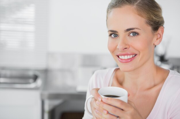 Radiante mujer rubia con café