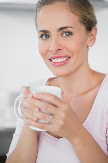 Radiante mujer rubia tomando café