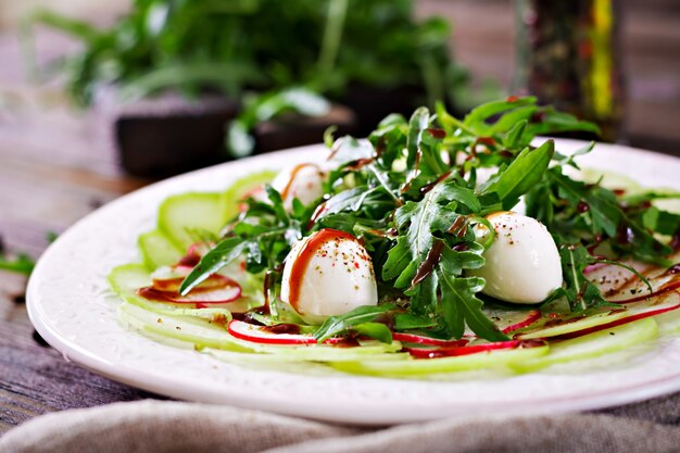 Radieschen-Carpaccio mit Rucola, Mozzarella und Balsamico-Sauce. Gesundes Essen. Daikon-Salat.