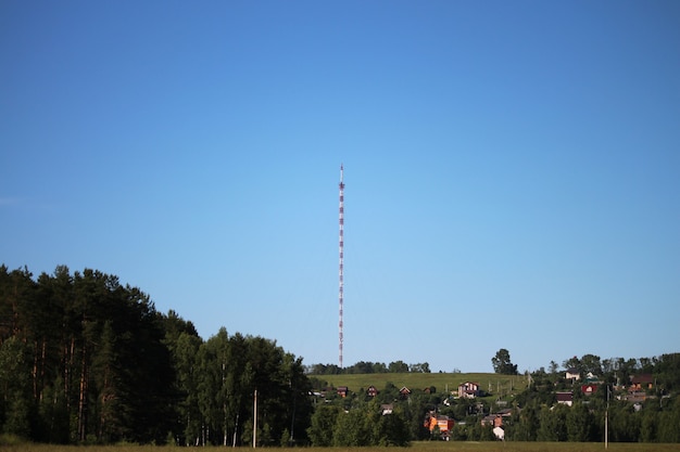 Radio-Fernsehturm mit Abspanndrähten gegen den klaren, tiefblauen Himmel, Nahaufnahme. Rot-weiße Gitterkonstruktion aus Stahl. Exemplar.