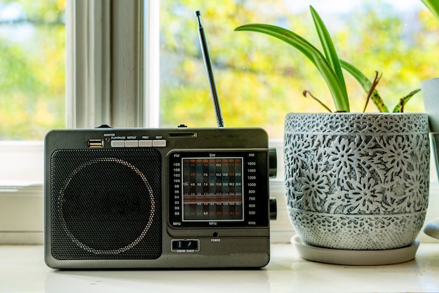 Foto radio retro antigua con antena en la ventana en casa tocando música f