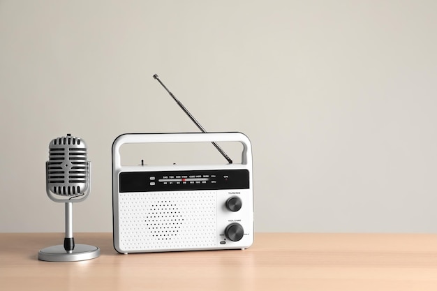 Radio retro y micrófono en la mesa contra la pared de luz