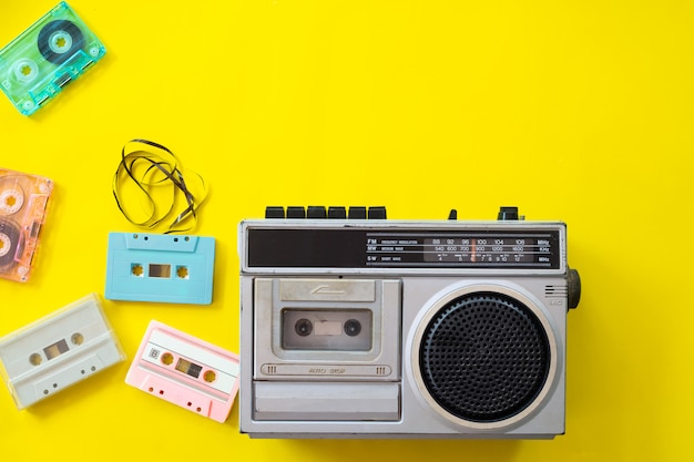 rádio vintage e toca-fitas em fundo amarelo