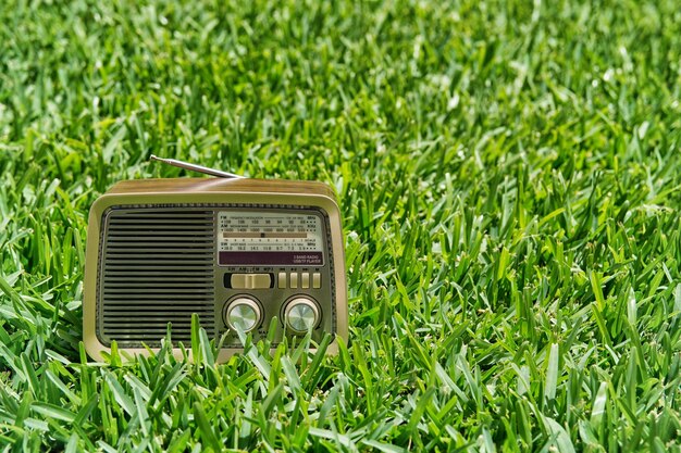 Foto rádio vintage em um fundo de grama verde. copiar espaço