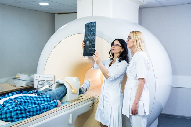 Radiologista com um paciente do sexo masculino examinando uma ressonância magnética.