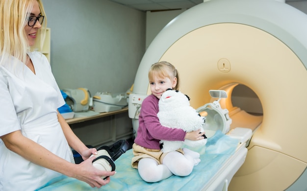 Radiologista prepara a menina para um exame de ressonância magnética do cérebro