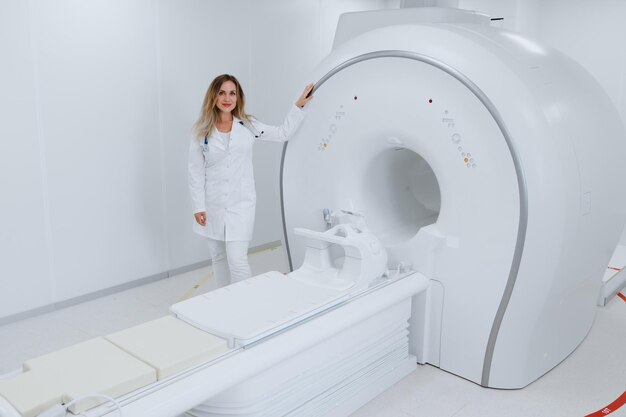 Un radiólogo profesional está parado en el laboratorio junto a una moderna máquina de tomografía computarizada