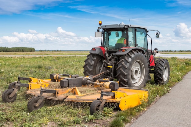 Radtraktor mit Rasenmäher an der Straße