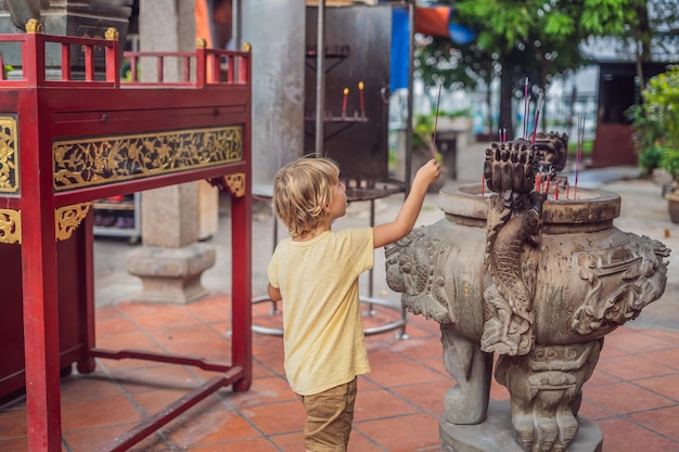 Räucherstäbchen auf Räucherstäbchen brennen und rauchen, um dem Buddha Respekt zu zollen, Räucherstäbchen in der Hand eines Jungen und Rauch verwenden, um Respekt vor dem Buddha im buddhistischen Leben zu beten